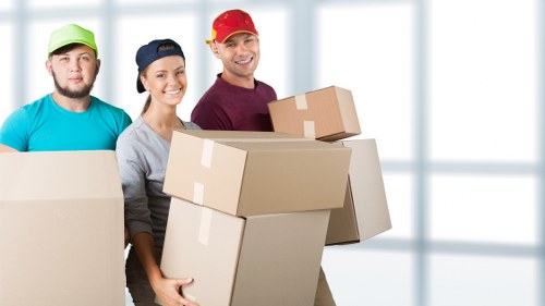 Removal staff in Westminster wearing PPE while carrying furniture