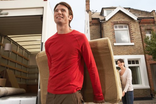 Moving team carrying furniture through Westminster street