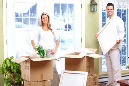 Removal team handling furniture from a townhouse staircase in Westminster